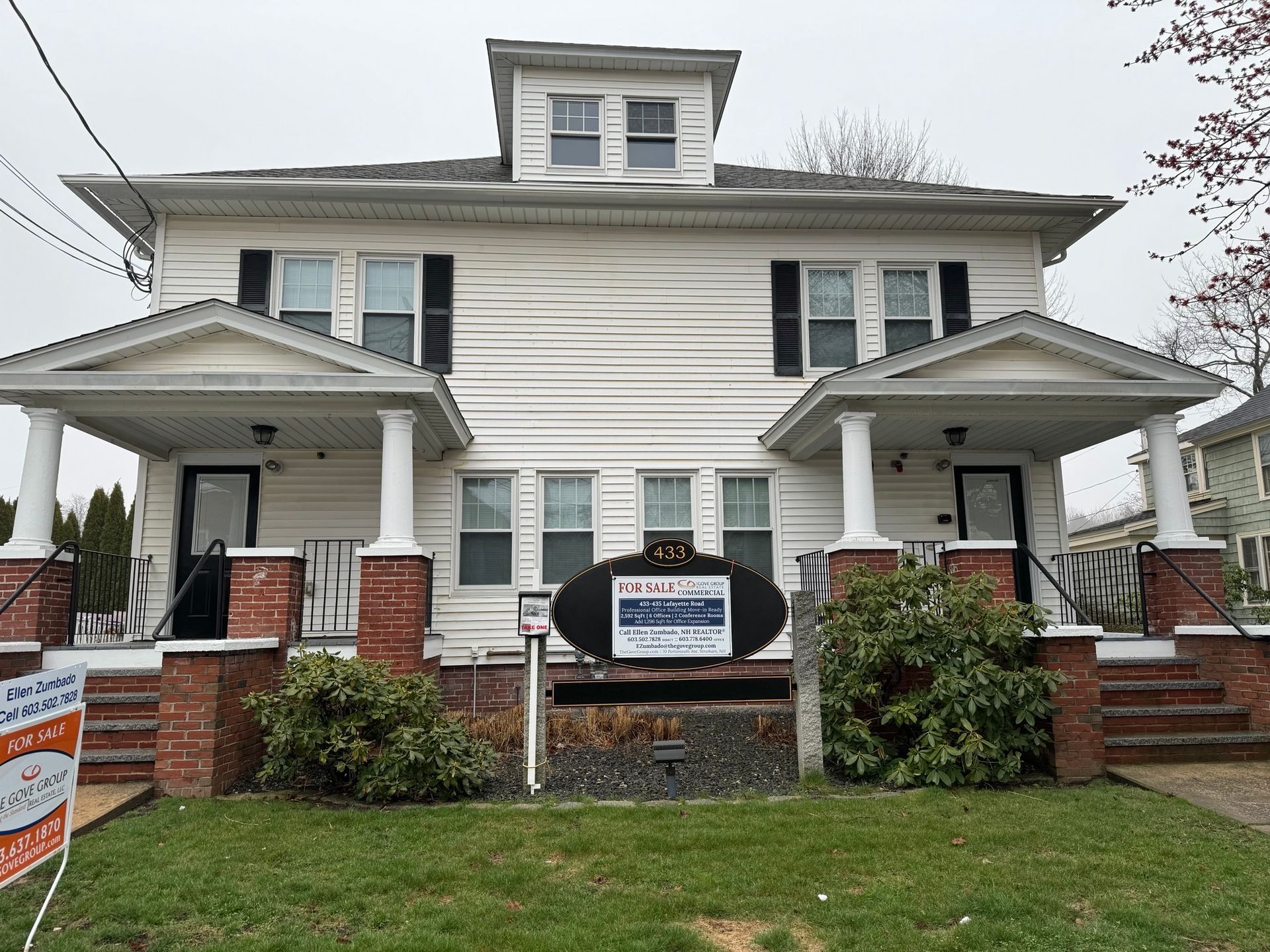 A white house with a for sale sign in front of it