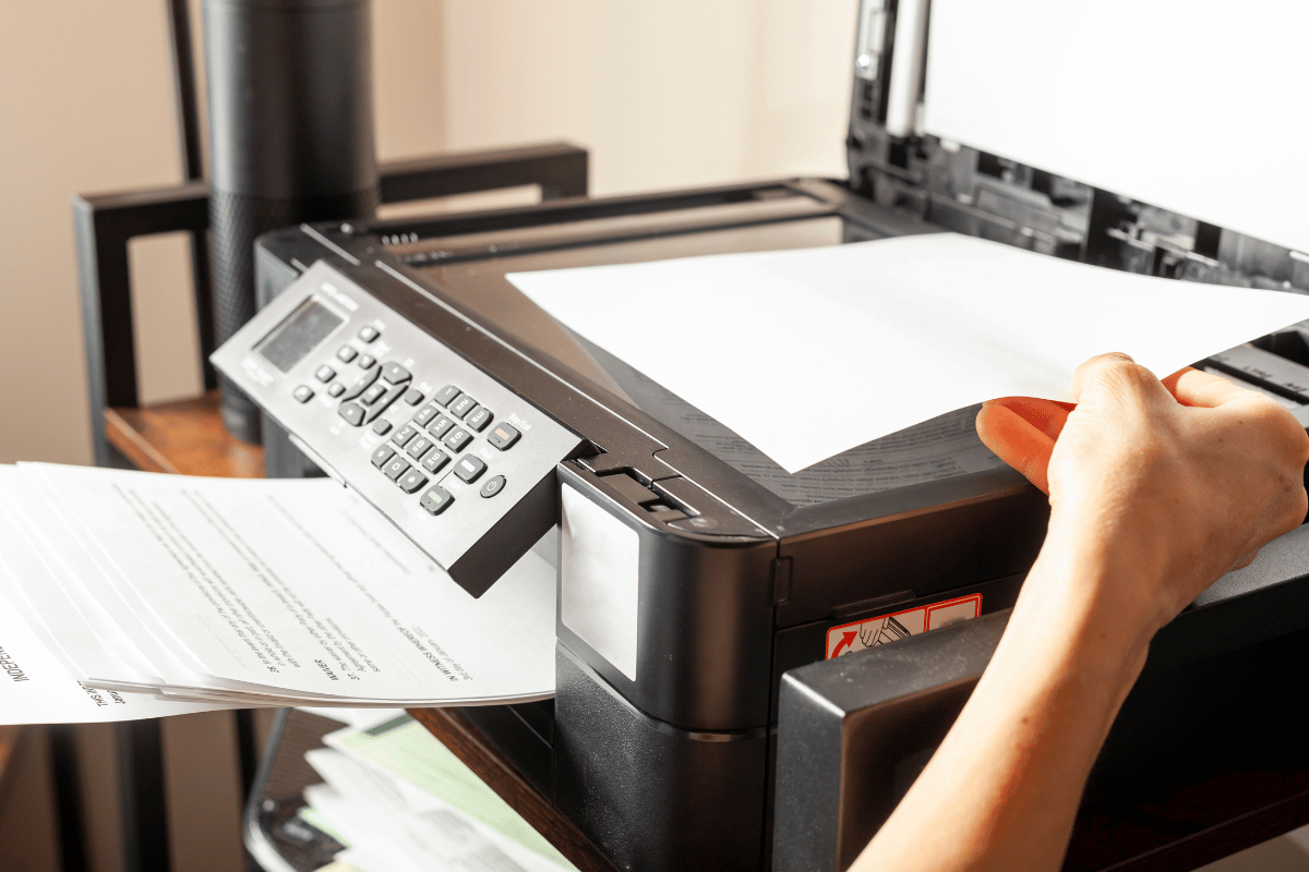 Wire baskets on sliding tracks inside a white closet, holding folded scarves and yarn.