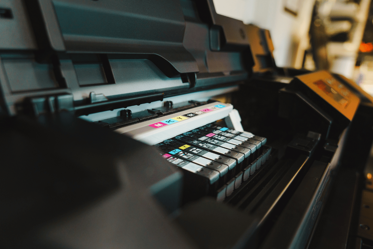 Wire baskets on sliding tracks inside a white closet, holding folded scarves and yarn.