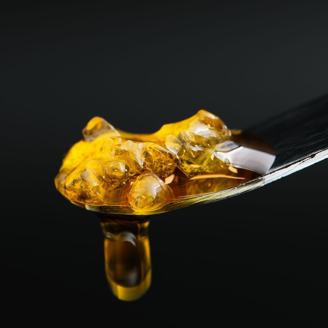 Dripping diamonds and sauce on a dab tool with a black background