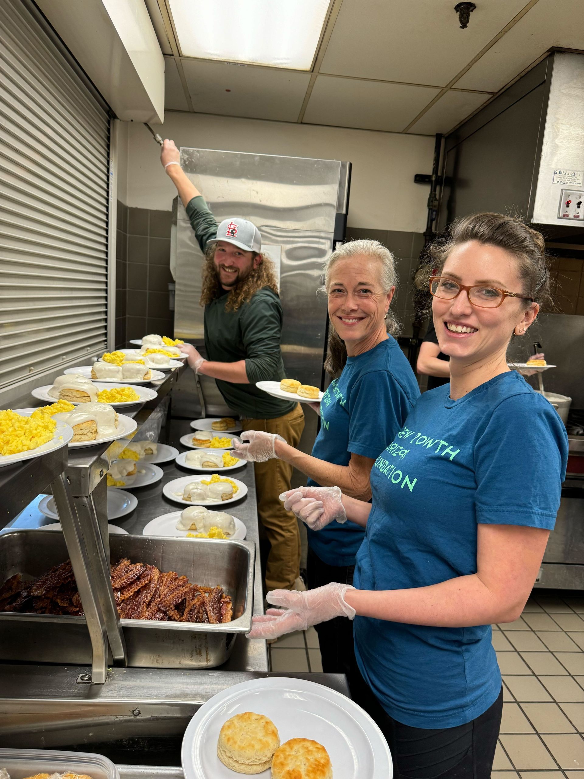 Three NGH volunteers serving meals at the St. Patrick's Center