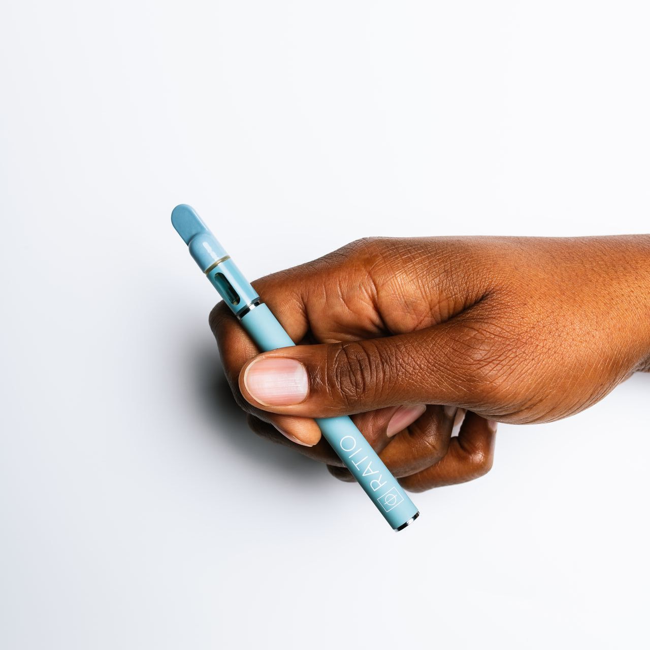 A hand holding a balance vape pen with the word RATIO on it