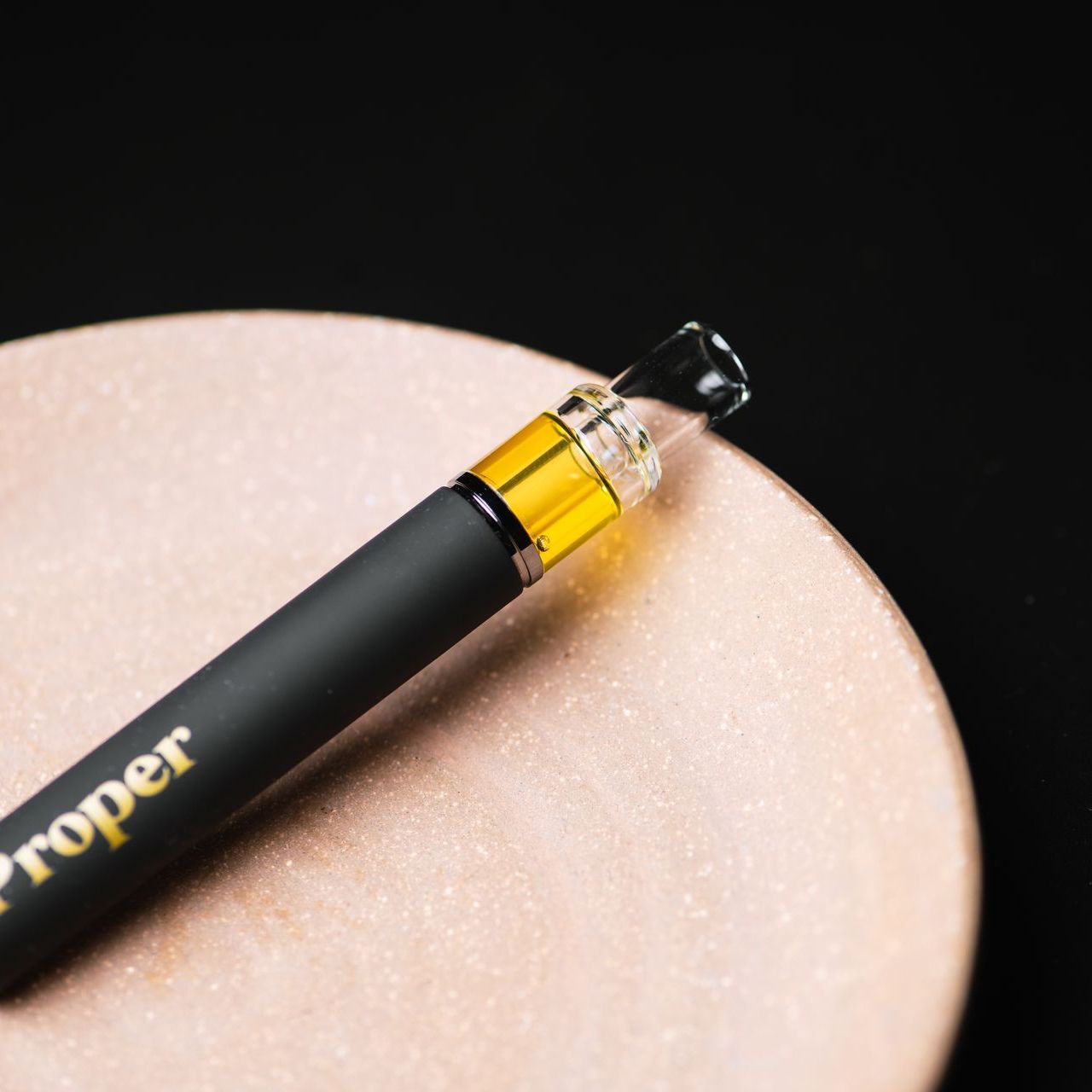 Rosin all in one vape on a terracotta plate with a black background