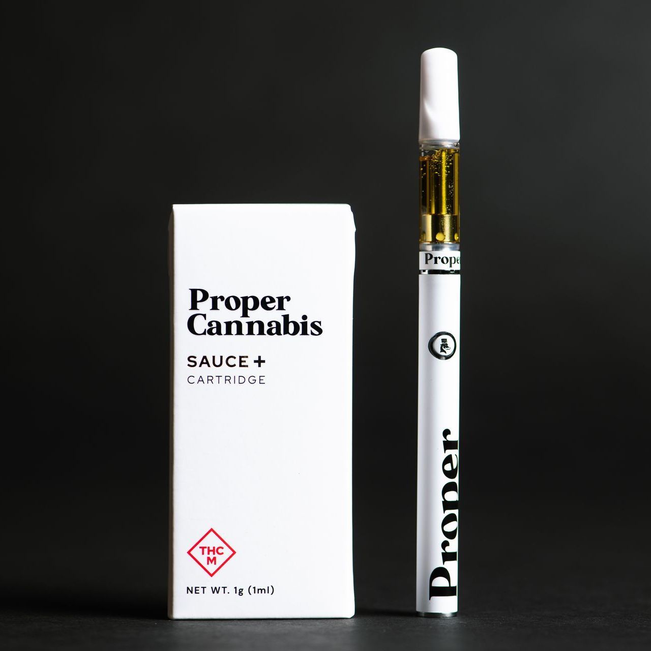 Proper Cannabis Sauce+ vape cartridge and box on a black background