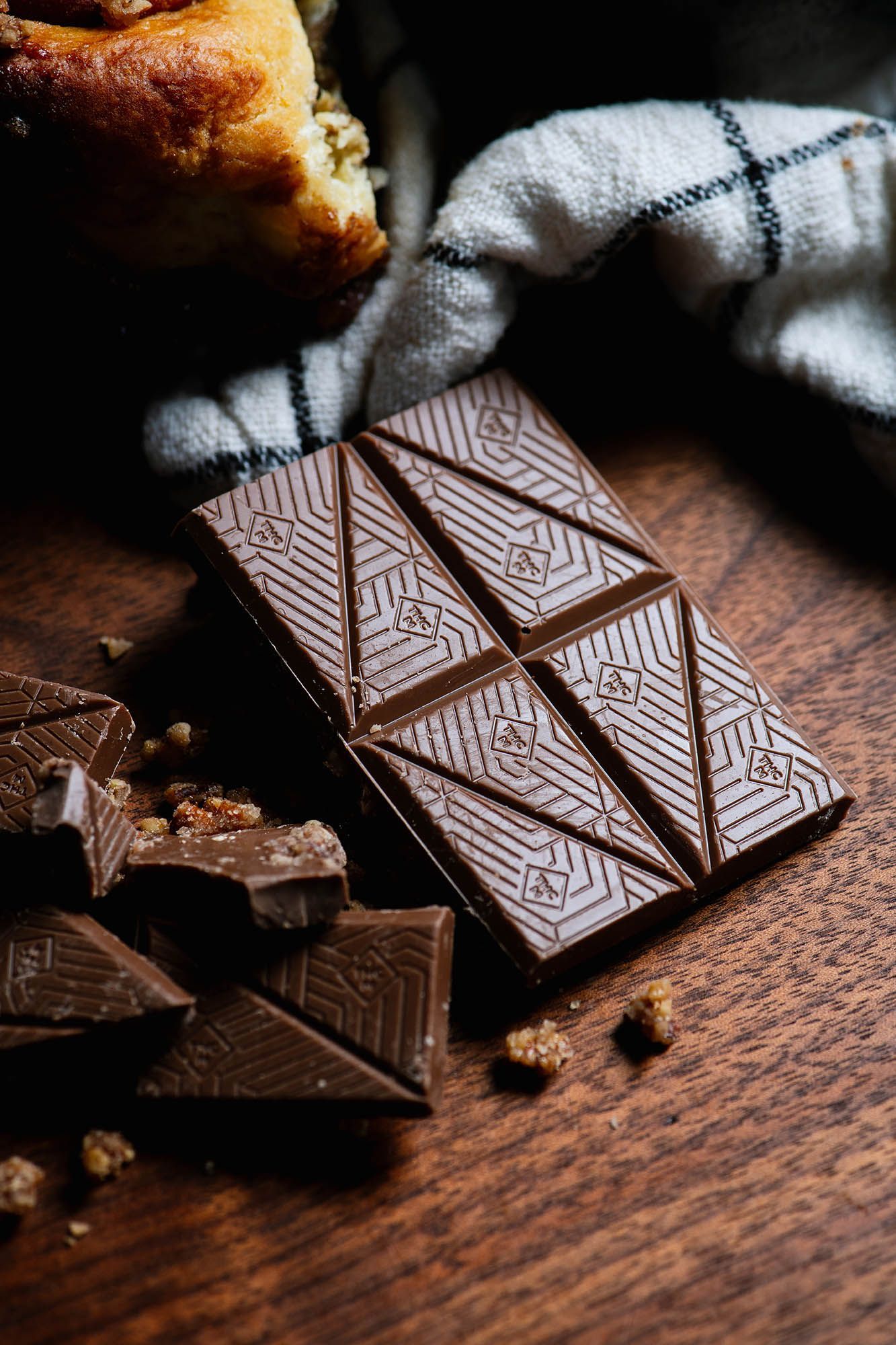A pile of Sticky Bun Honeybee chocolate on a wood top