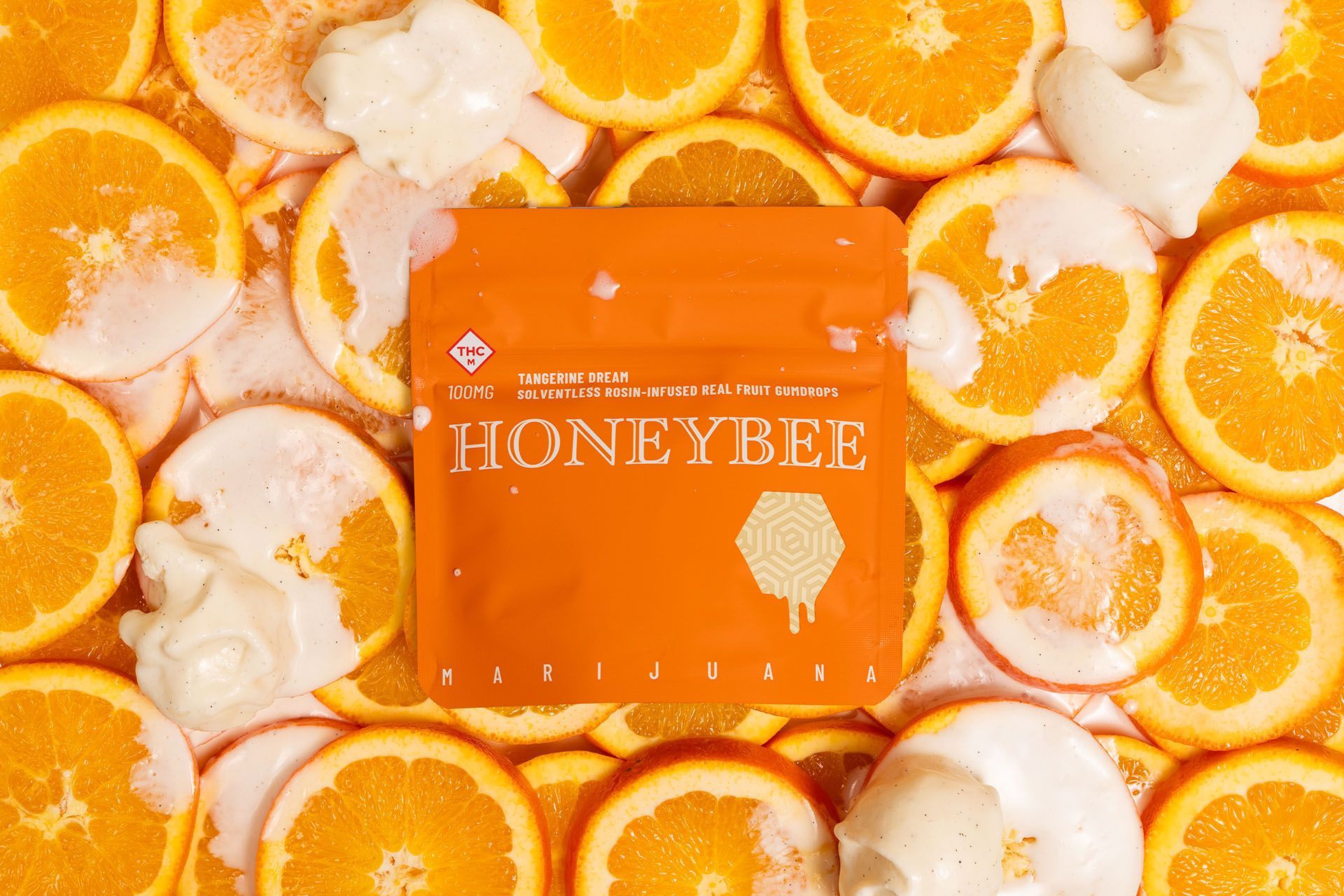 Tangerine Dream Honeybee rosin gumdrop bag on a pile of oranges with melting ice cream