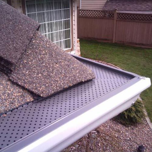 A person is cleaning a gutter on a roof.