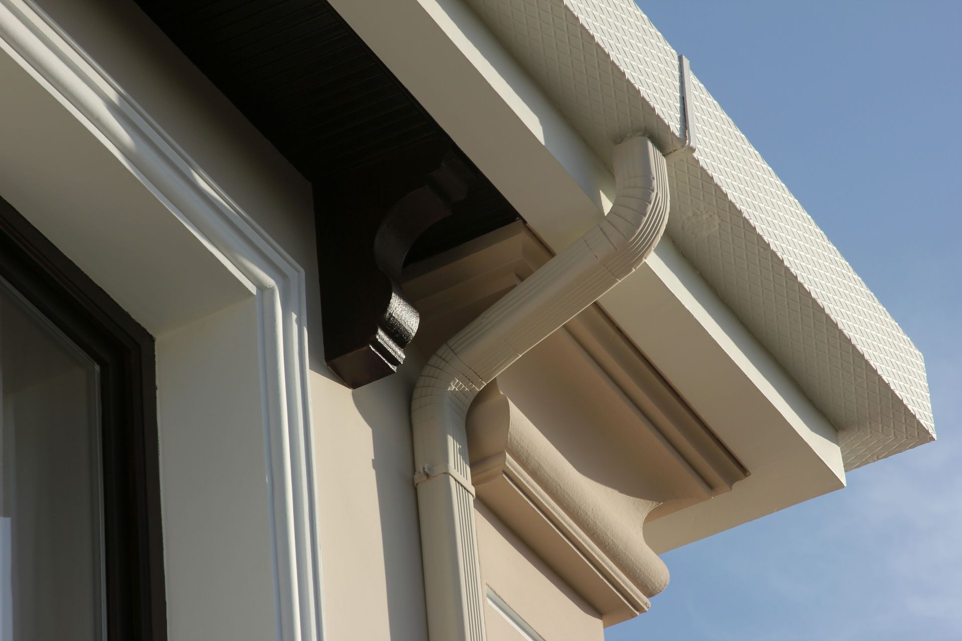 A close up of a gutter on the side of a building