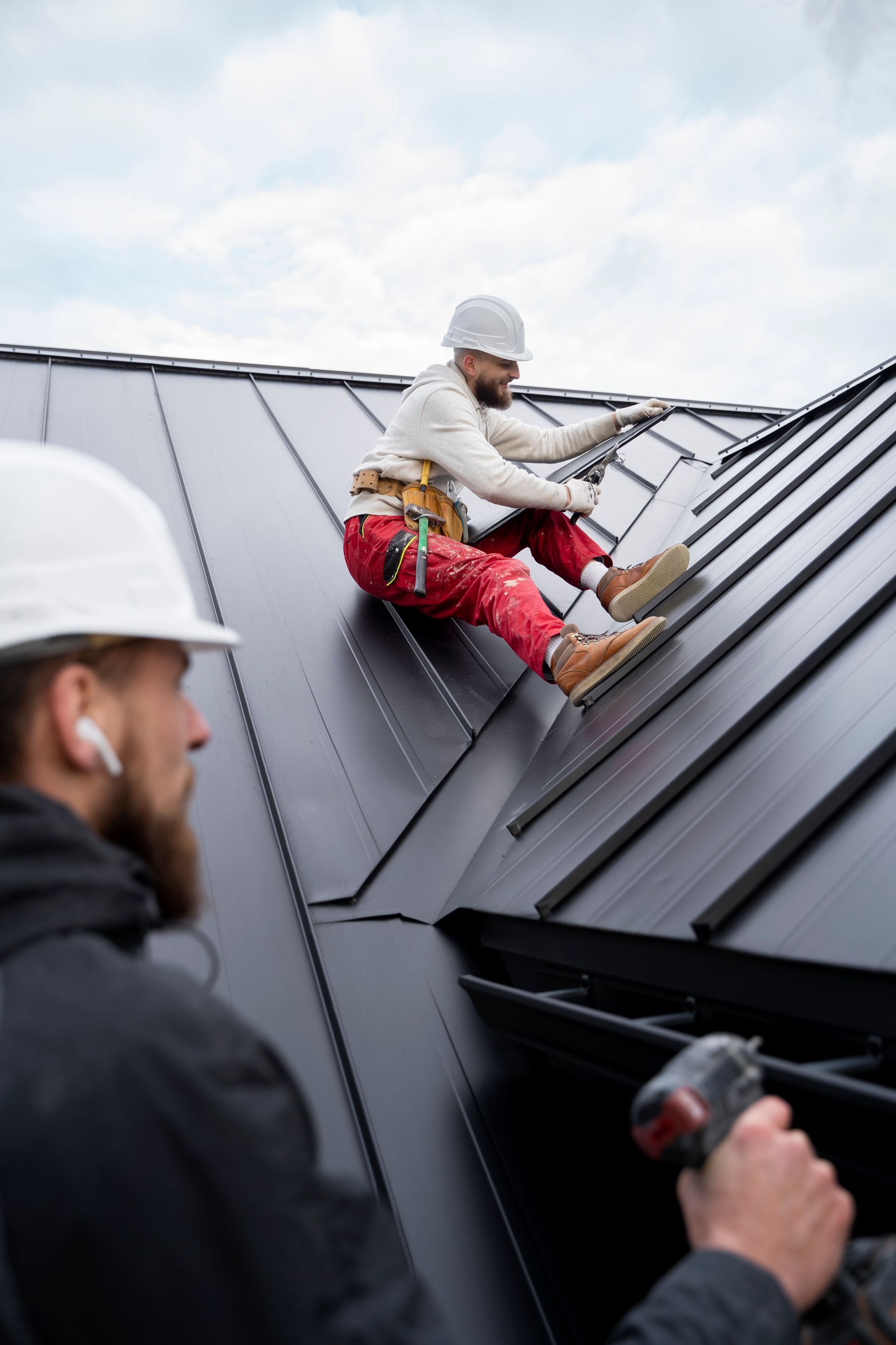 Two men are working on the roof of a building.