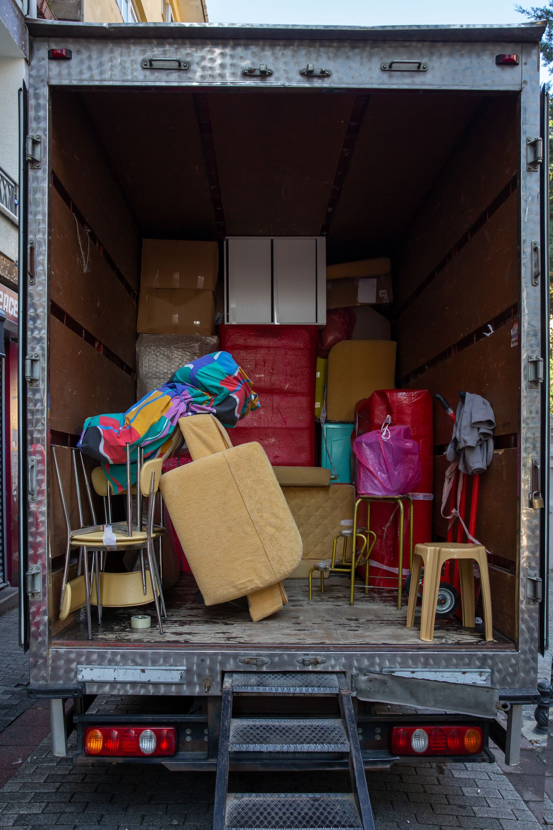 The back of a moving truck filled with furniture and boxes.