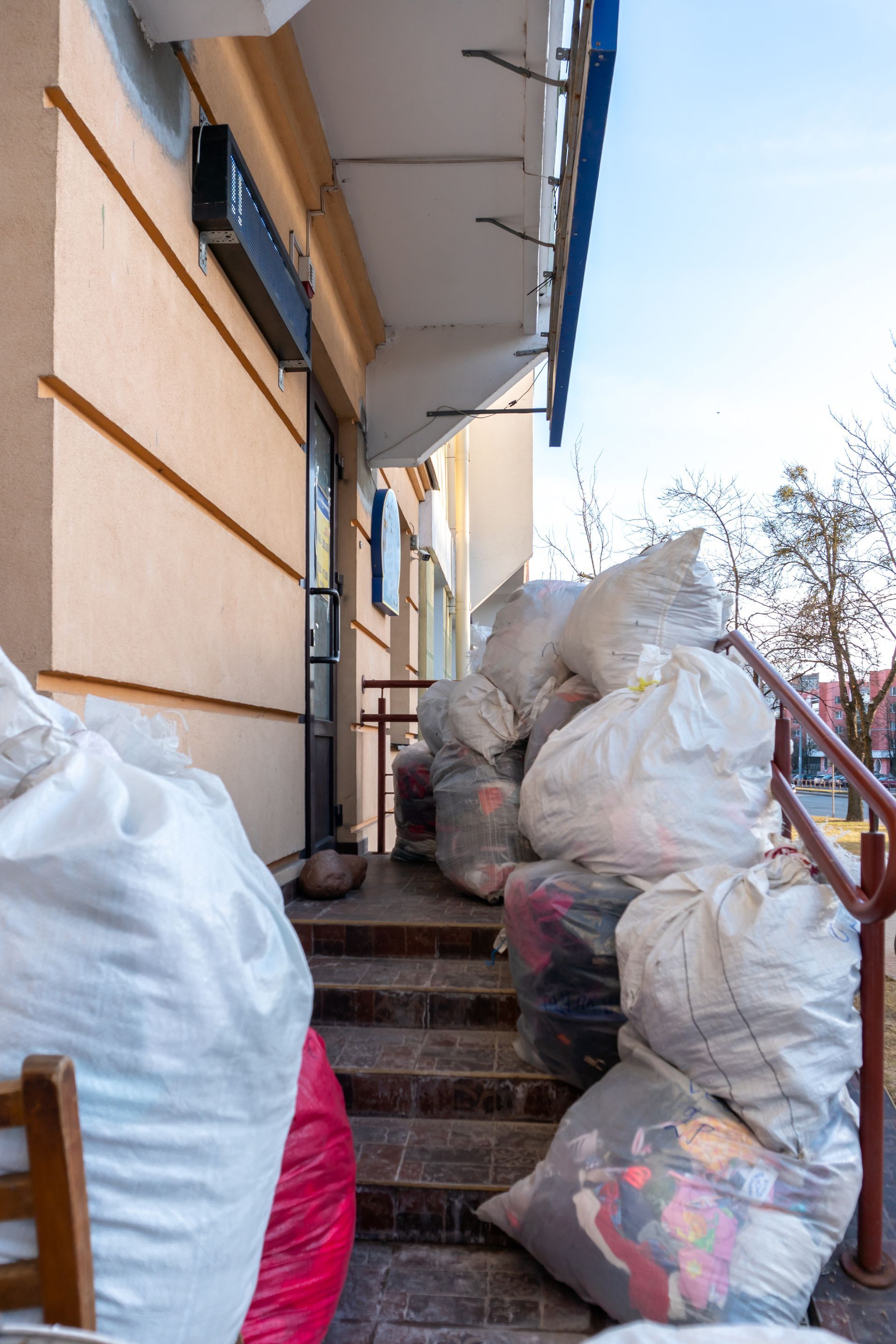 A pile of bags sitting on the steps of a building.