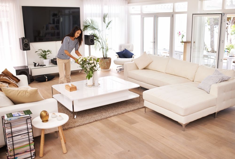 A woman is arranging flowers in a living room.