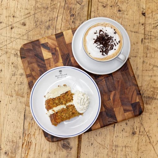 A slice of cake and a cup of coffee on a wooden table