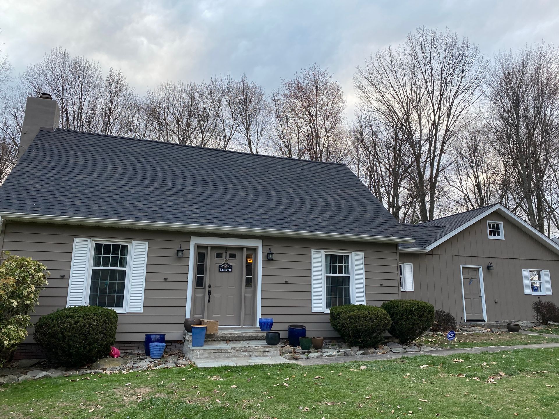 A house with a black roof and white shutters