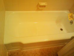 A white bathtub is sitting in a bathroom next to a toilet.