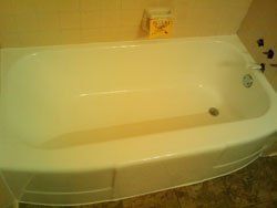 A white bathtub is sitting in a bathroom next to a wall.