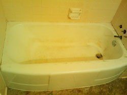 A white bathtub is sitting in a bathroom next to a wall.