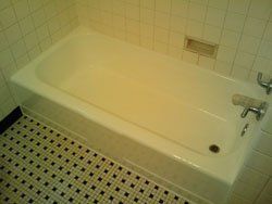 A bathtub in a bathroom with a tiled floor.