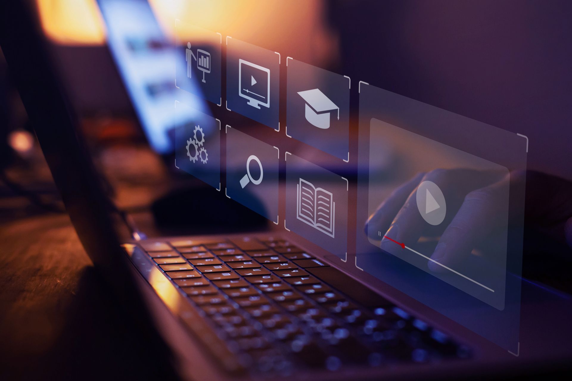 Laptop with digital icons related to online education, glowing on the screen.
