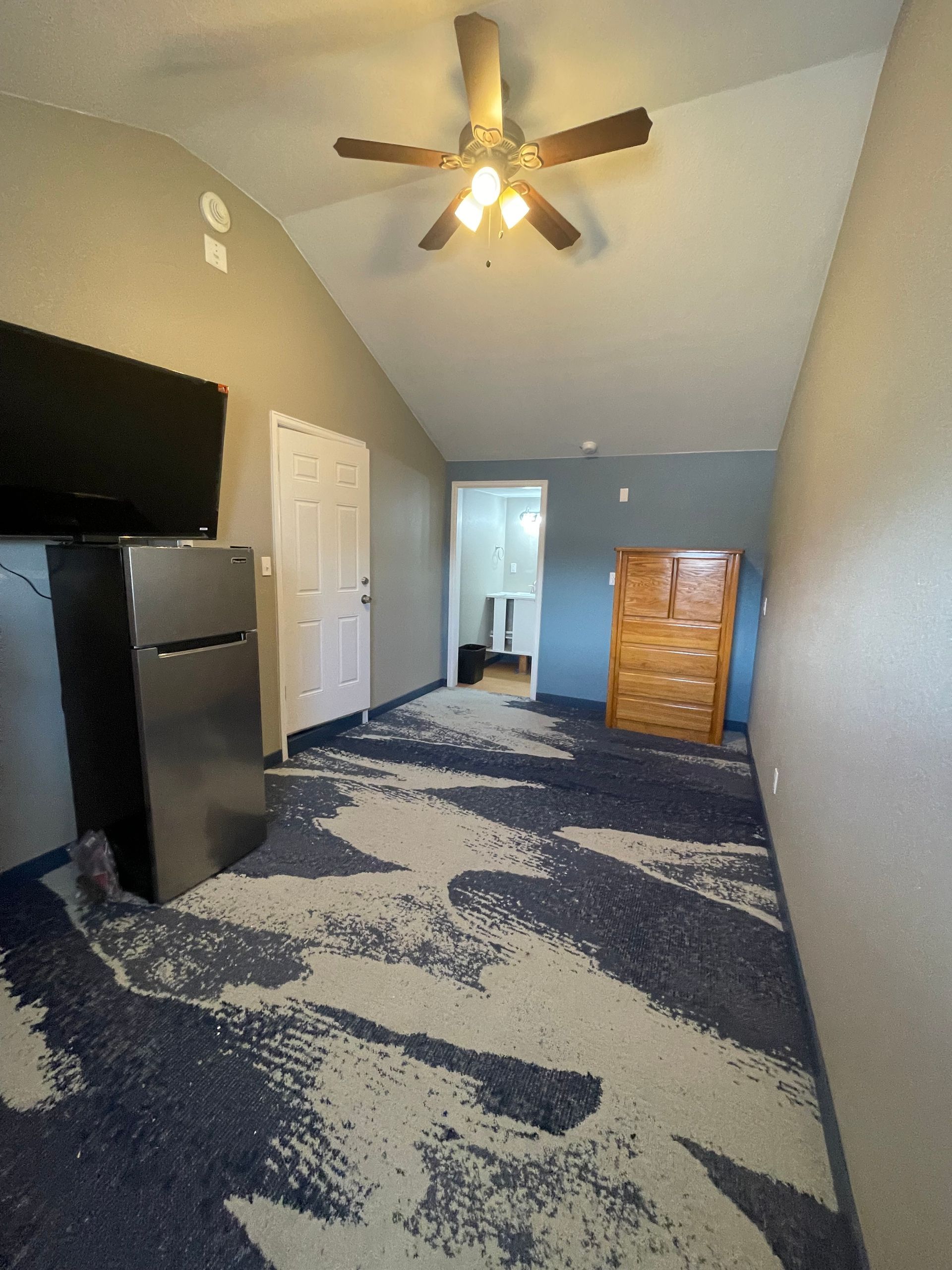 Cozy hotel room with a fireplace, bunk beds, and a bed facing a mountain view through large windows.