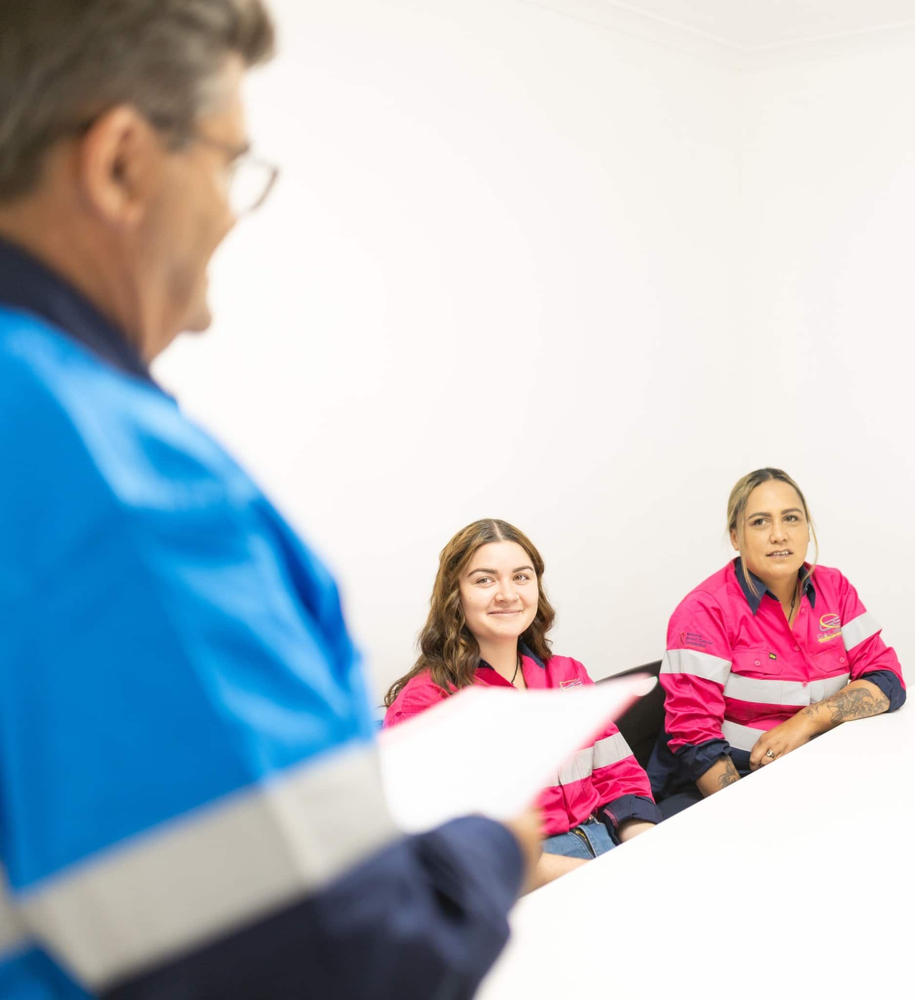 A Man in a Blue Jacket is Giving a Presentation to Two Women — Calibre Resourcing Solutions in Mount Isa City, QLD
