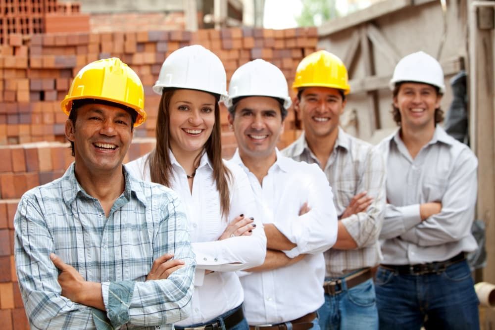 A Group of Construction Workers Wearing Hard Hats Are Posing for a Picture — Calibre Resourcing Solutions in Mount Isa City, QLD