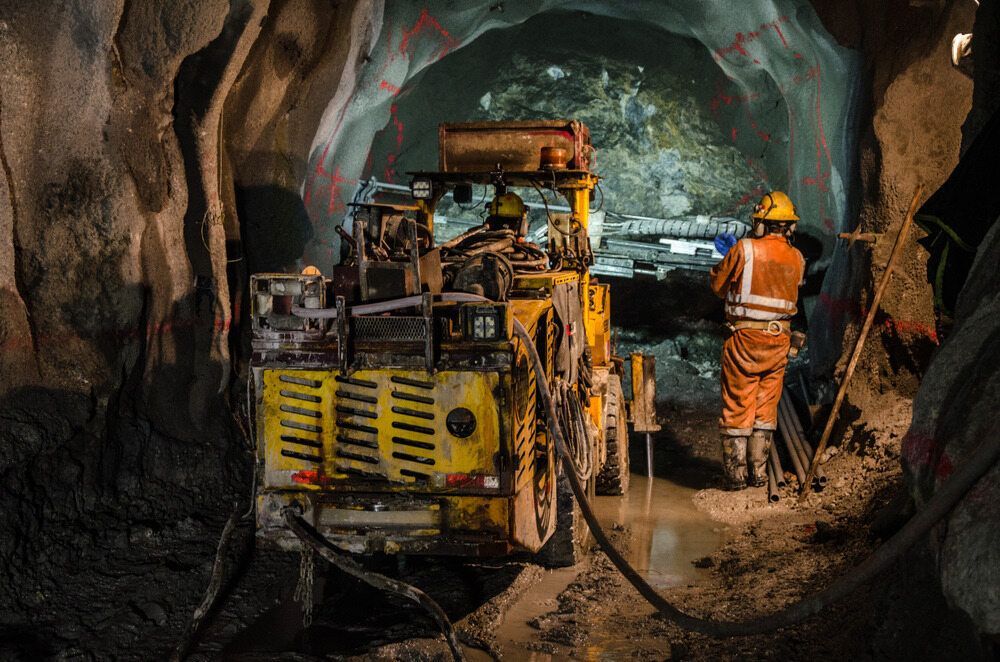 A Man is Standing Next to a Machine in a Tunnel — Calibre Resourcing Solutions in Mount Isa City, QLD