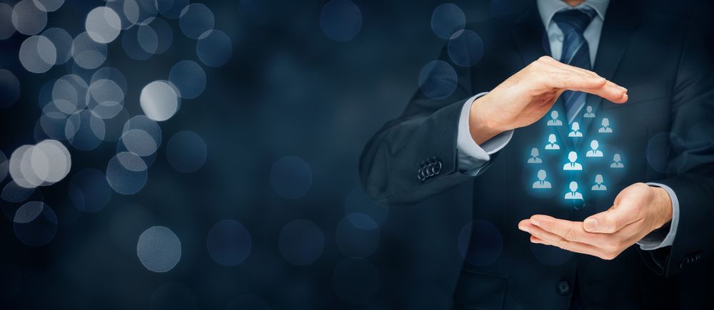 A Man in a Suit and Tie is Holding a Group of People in His Hands — Calibre Resourcing Solutions in Mount Isa City, QLD