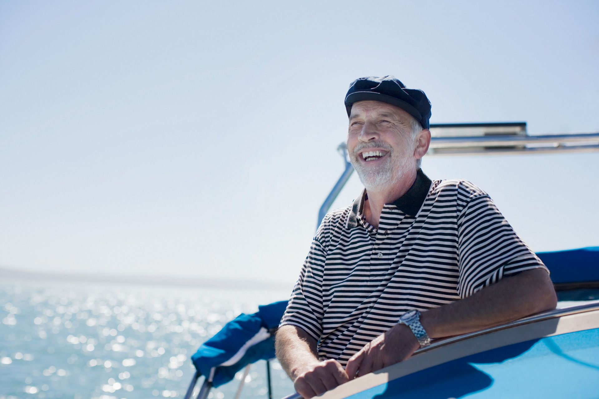 An older man is sitting on a boat in the water.