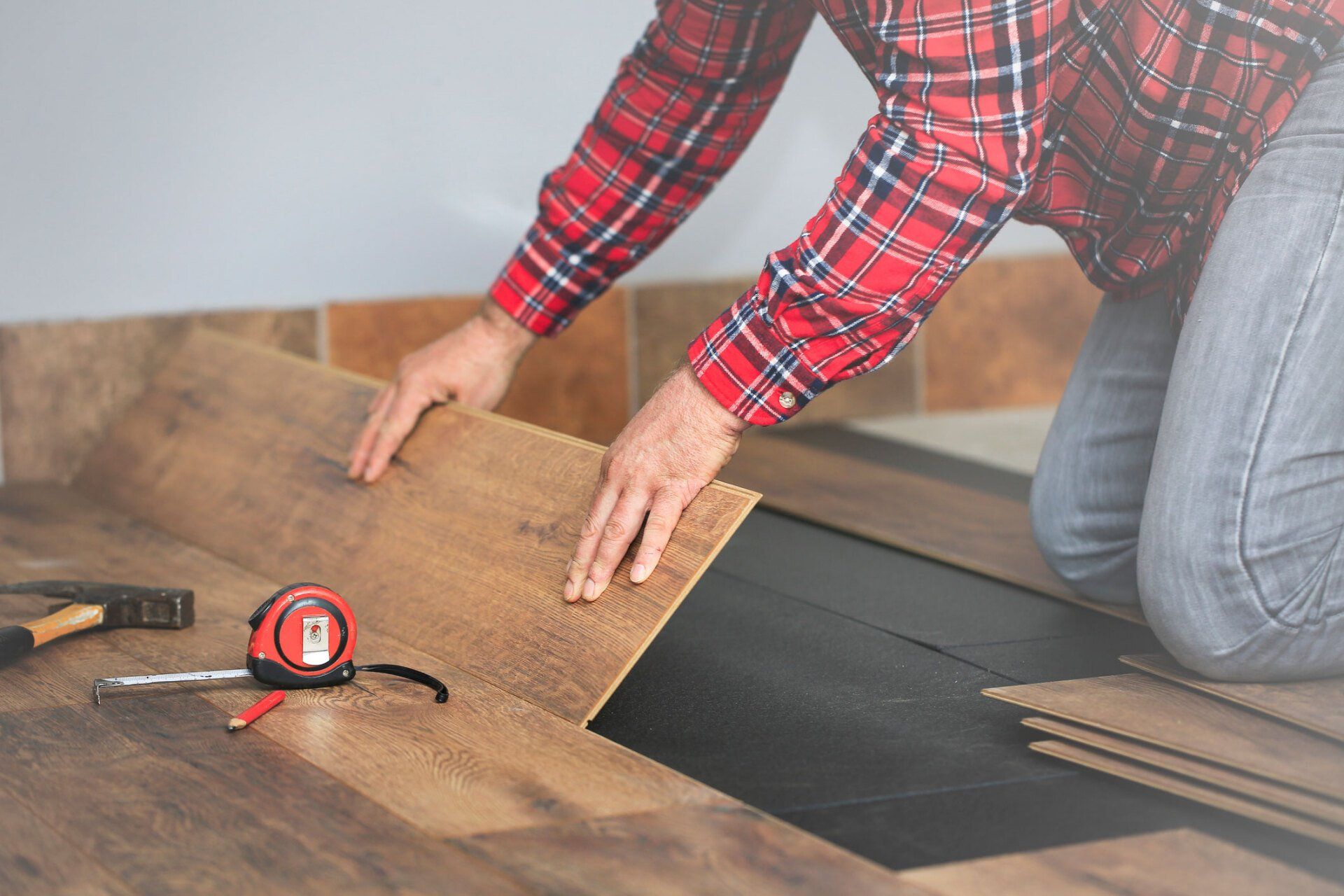 Man installing flooring — Lexington, KY — Handy Manny’s
