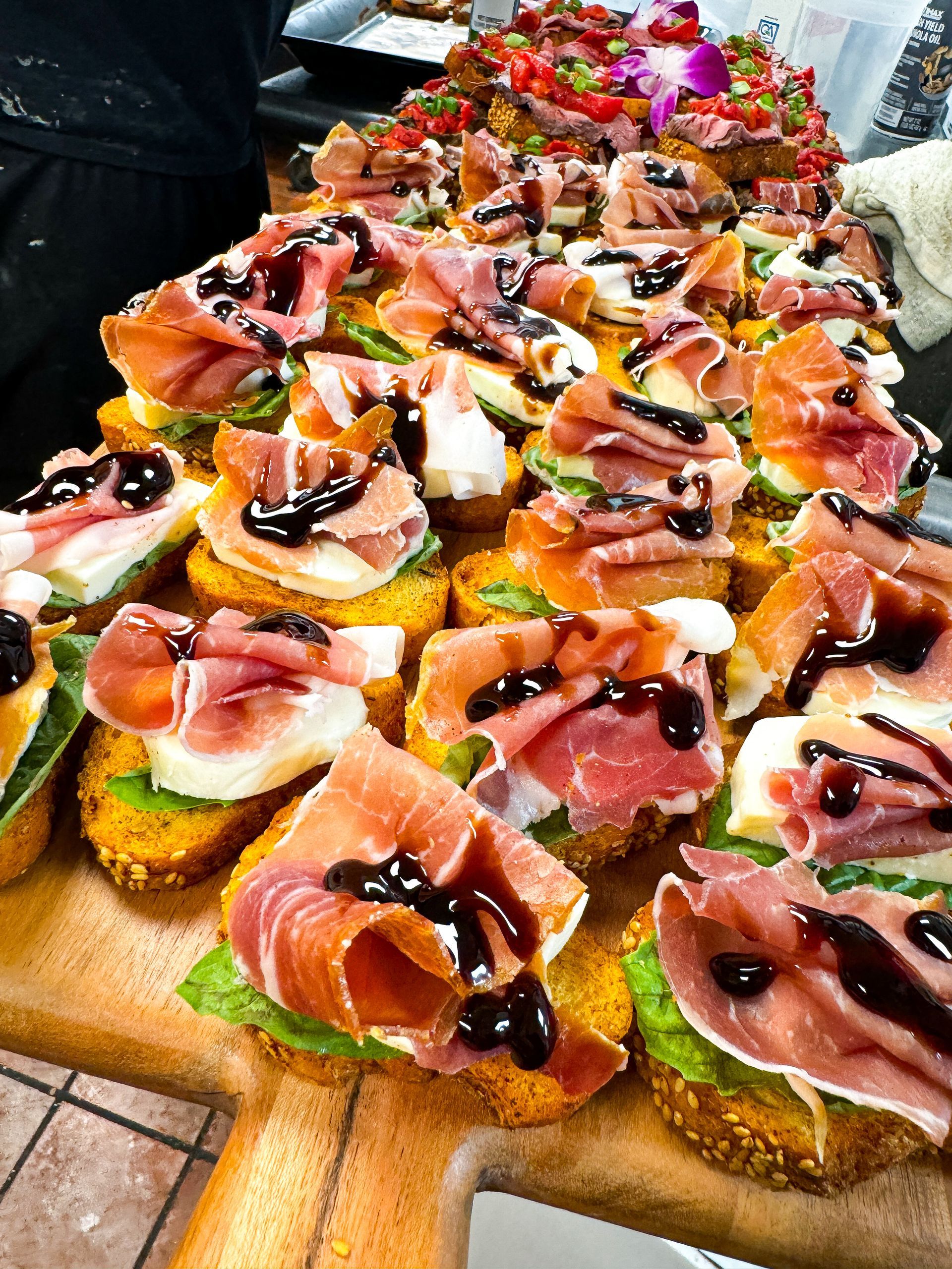 A well-lit reception hall with round tables set for a celebration. Pink and gold decor.