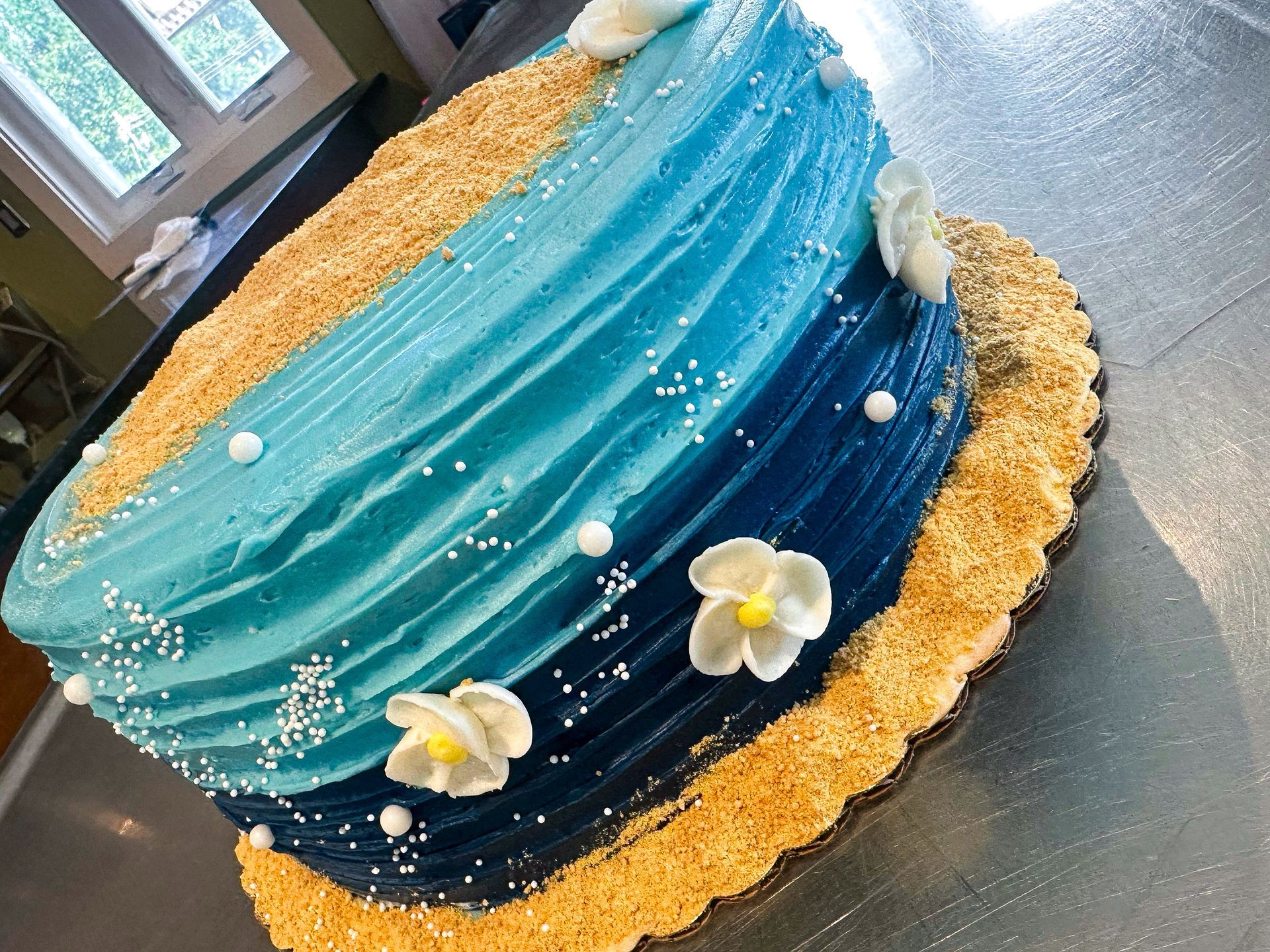 Cake decorated as an ocean wave with blue frosting, edible 
