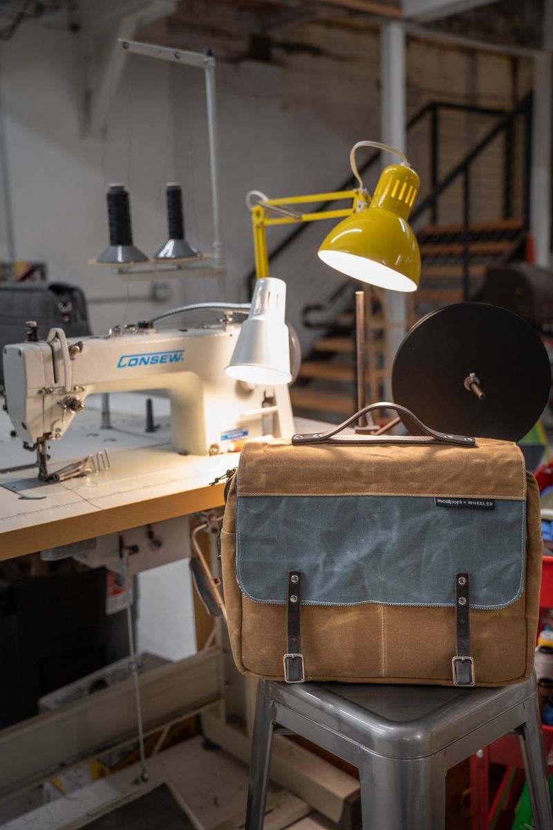 A bag is sitting on a stool in front of a sewing machine.