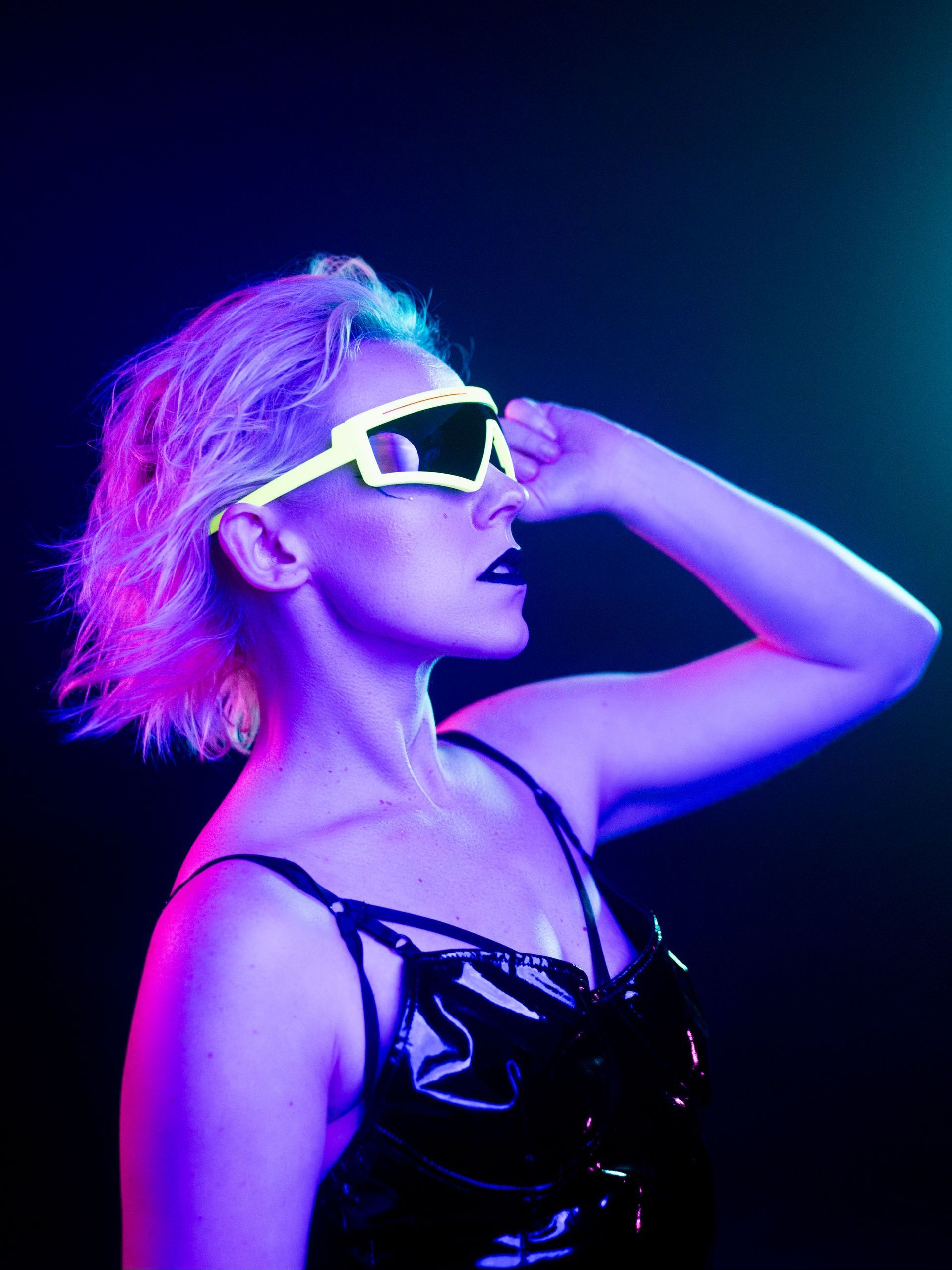 A portrait of a  woman with colorful pink and blue studio lighting