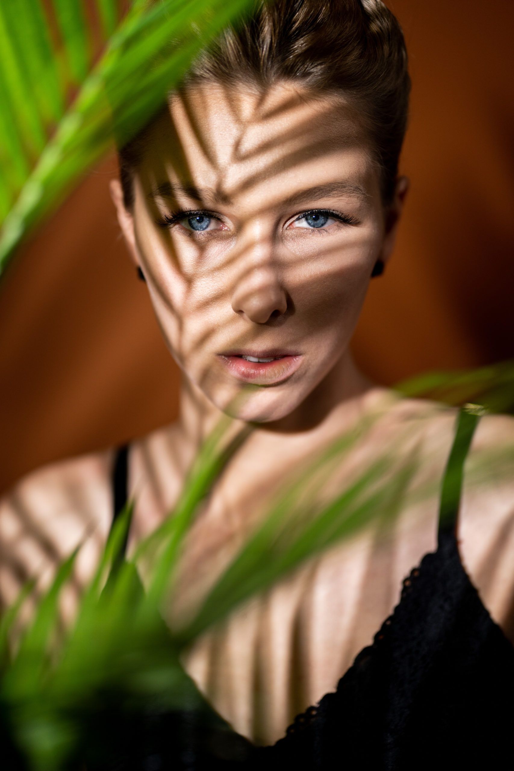 The shadow of a palm tree is cast on a woman 's face.