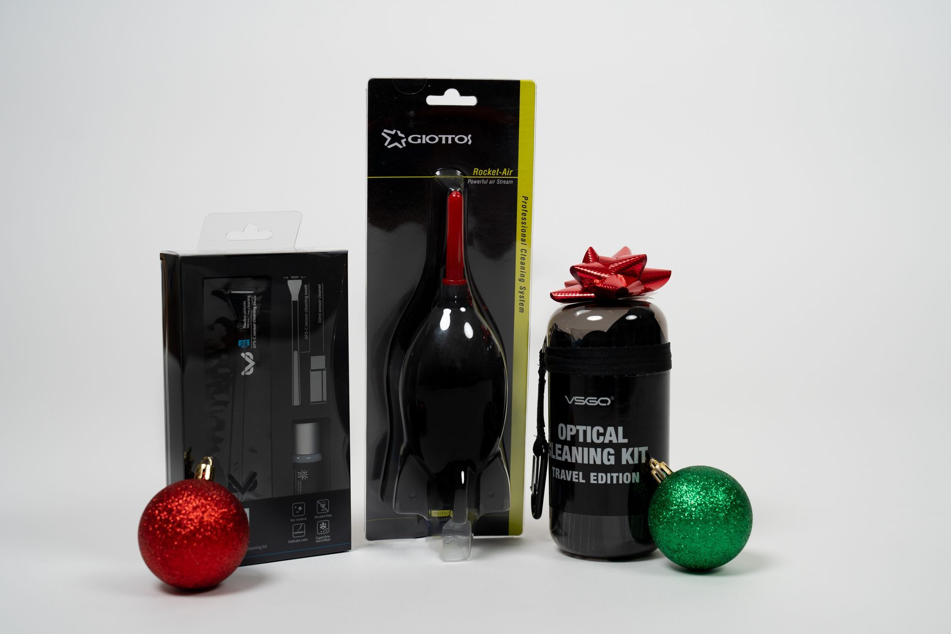 A bottle of optical cleaning kit is sitting next to a christmas ball.