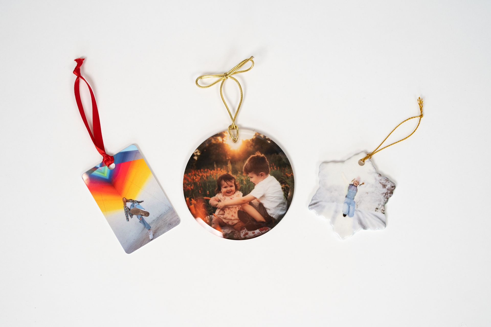 Three christmas ornaments with pictures on them are sitting on a table.