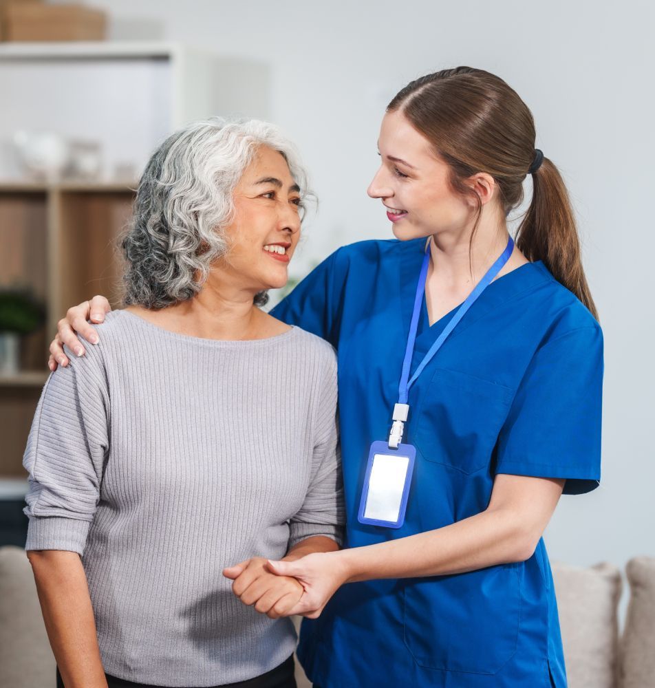 A nurse is talking to an elderly woman in a living room.