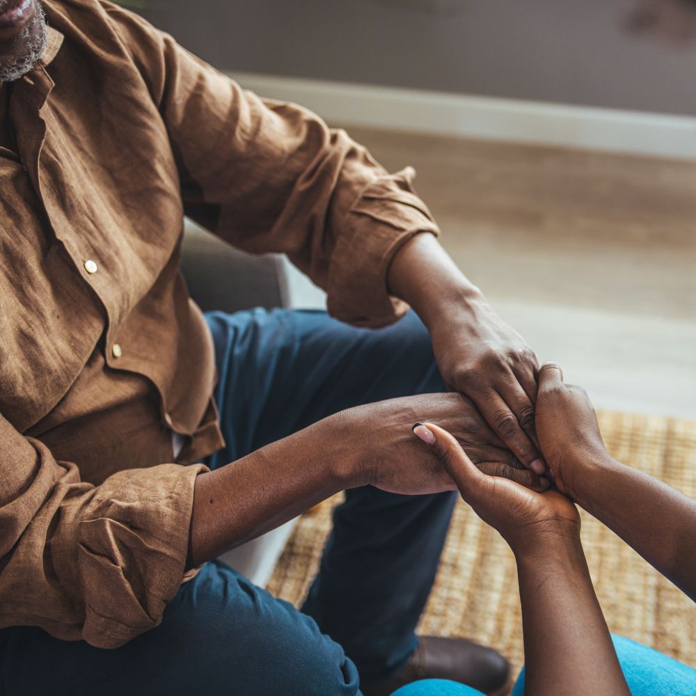 A man in a brown shirt is holding a woman 's hand