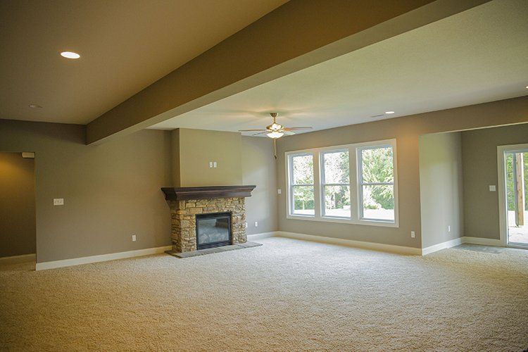 Carpeted Empty Living Room With Fireplace by Hansman Custom Homes in Mid-Missouri