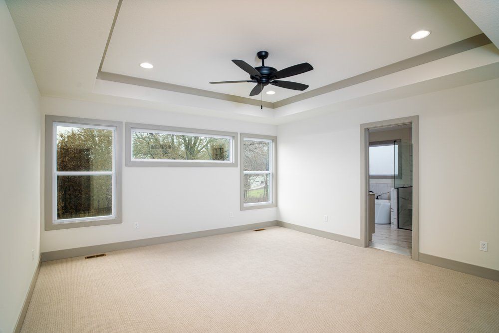 Spacious Empty Room With Ceiling Fan by Hansman Custom Homes in Mid-MO