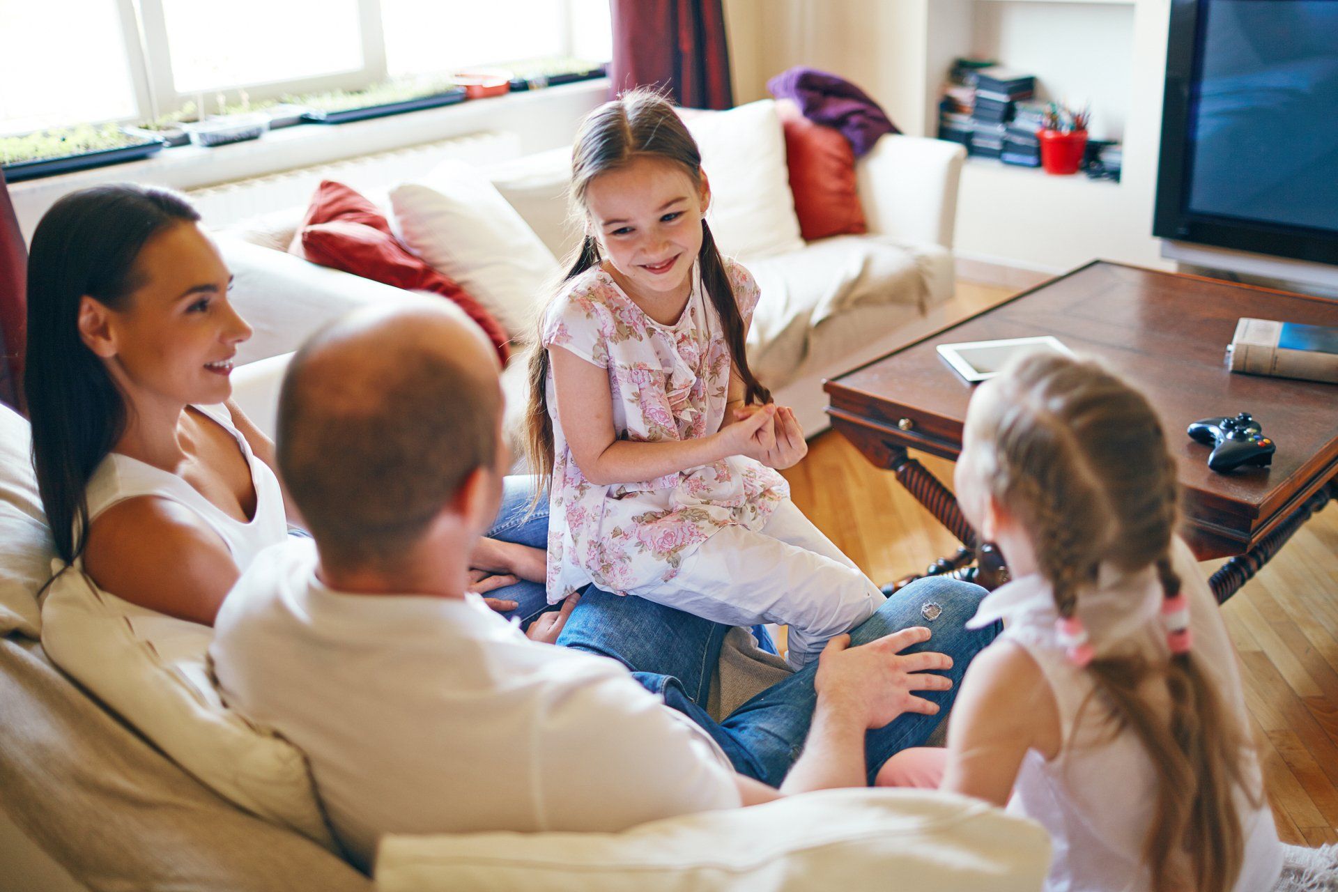 A family of four on a couch. Plan your family for a mid-Missouri custom home with Hansman Custom Homes.