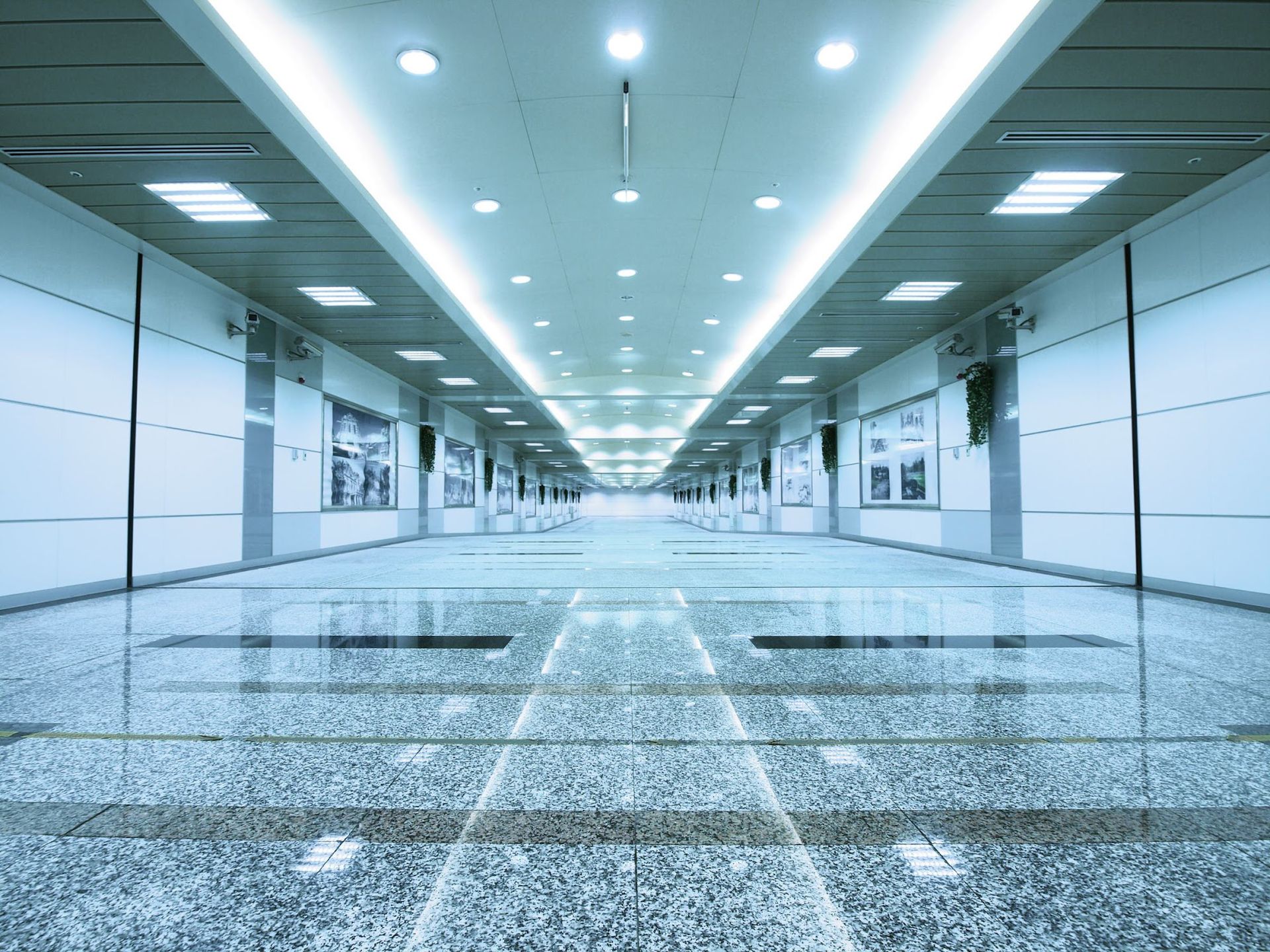 A long hallway in a building with a marble floor and ceiling.