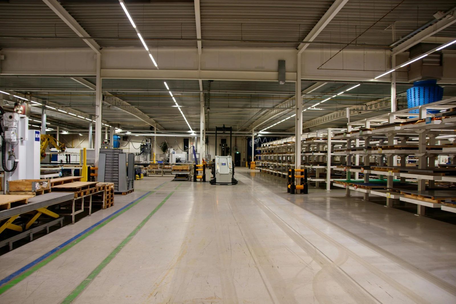 Large industrial warehouse interior with shelving units and equipment.