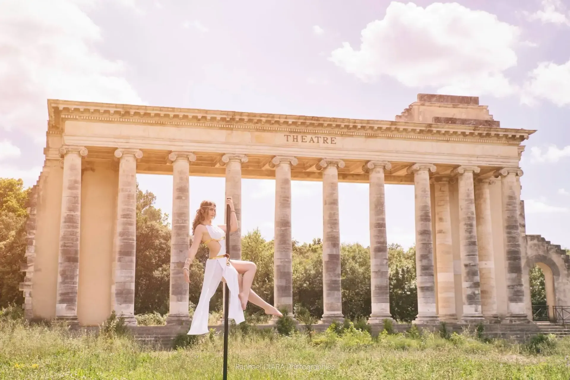 Une femme se tient devant un bâtiment à colonnes.