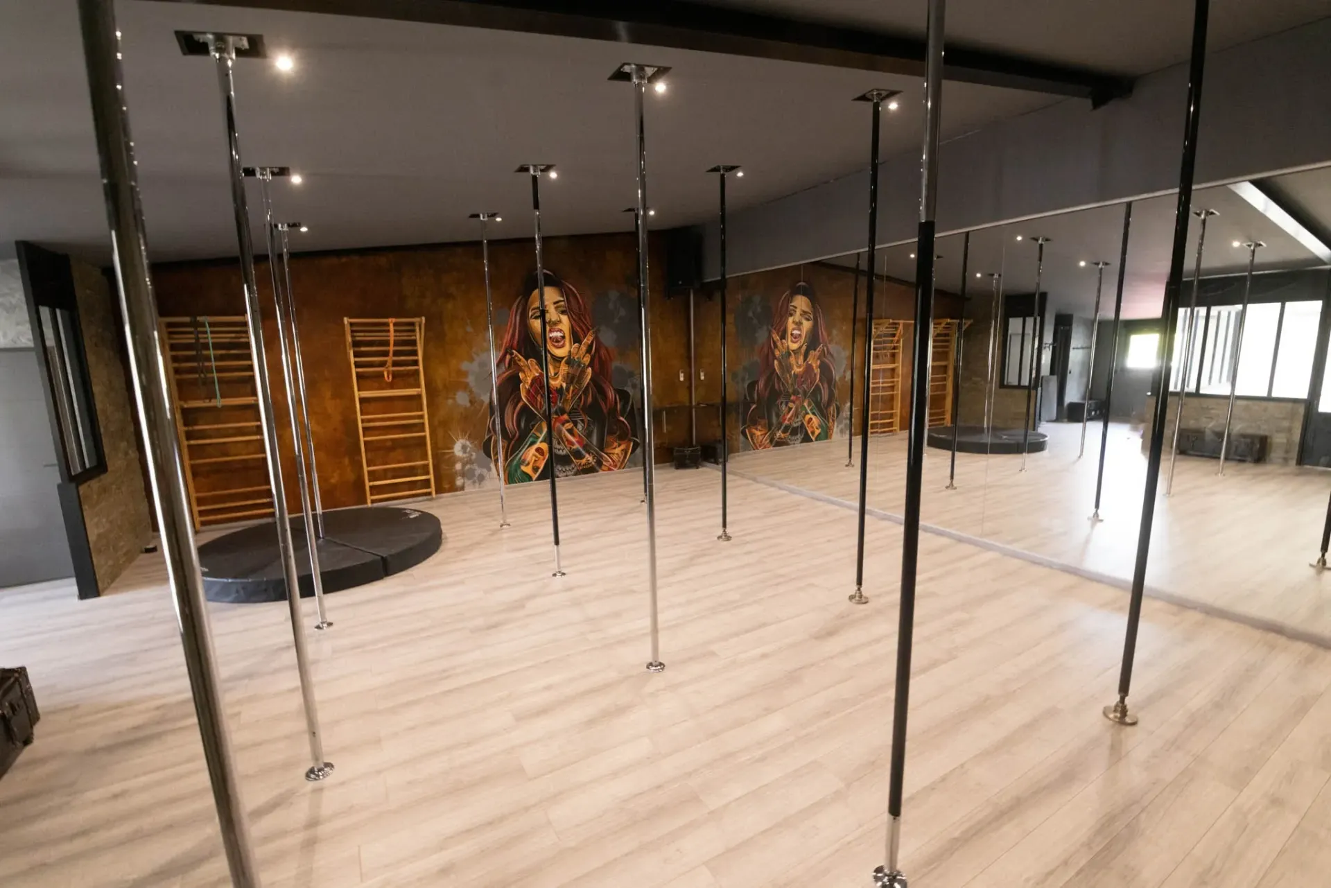 Une grande pièce vide avec des poteaux et un miroir.