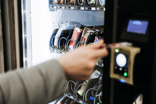 A person is using a credit card to buy a snack from a vending machine.
