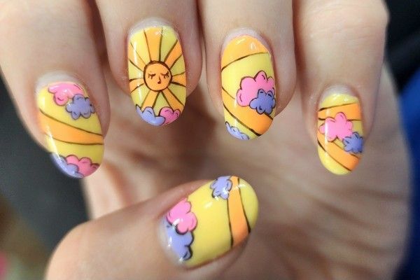 A close up of a person 's nails with a sun and cloud design