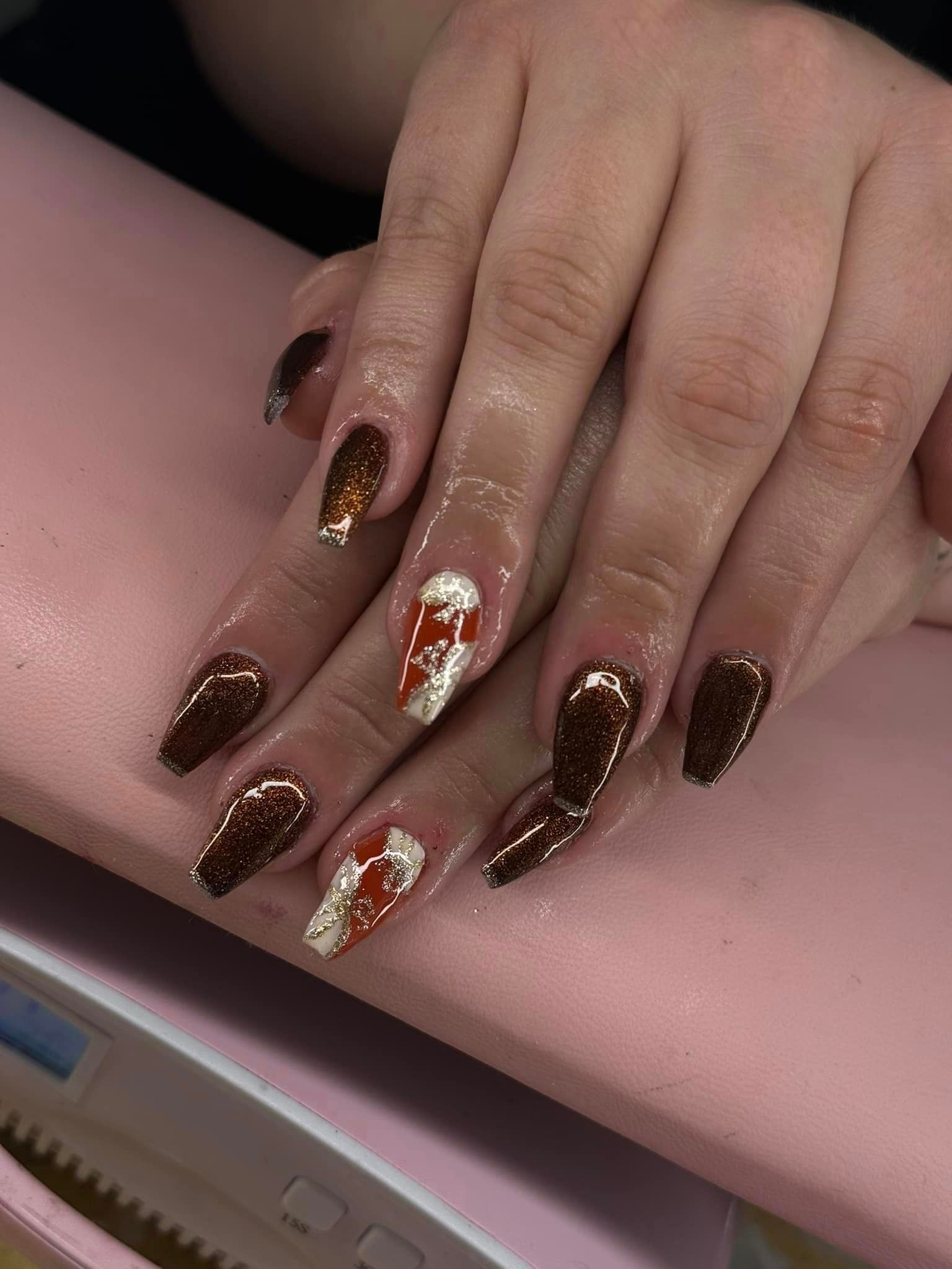 A close up of a woman 's nails on a pink pillow