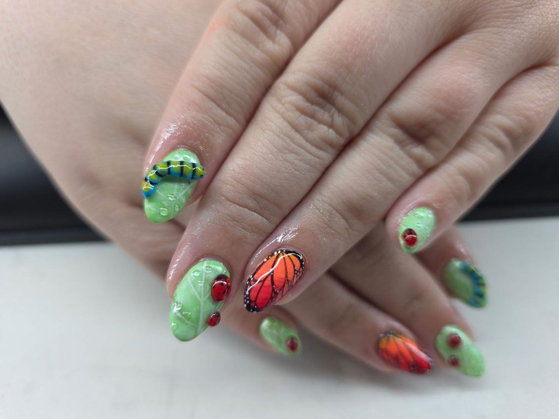 A close up of a person 's nails with a butterfly design on them.